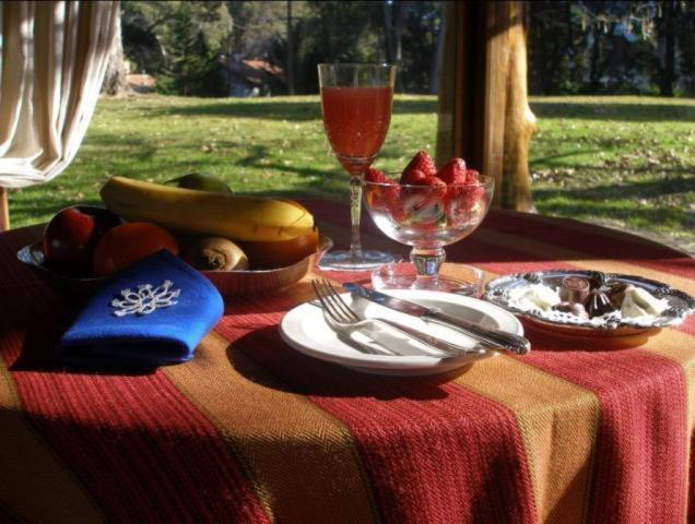 Mesa de desayuno con frutas junto a una ventana al jardín