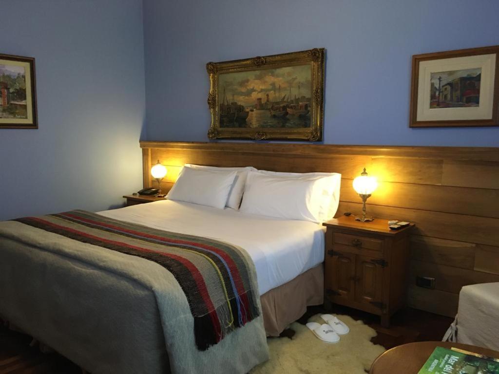 Habitación doble de Los Nobles Art con paredes azules, cabecera de madera y lámparas cálidas
